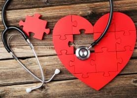 40576178 - red puzzle heart with stethoscope on brown wooden background